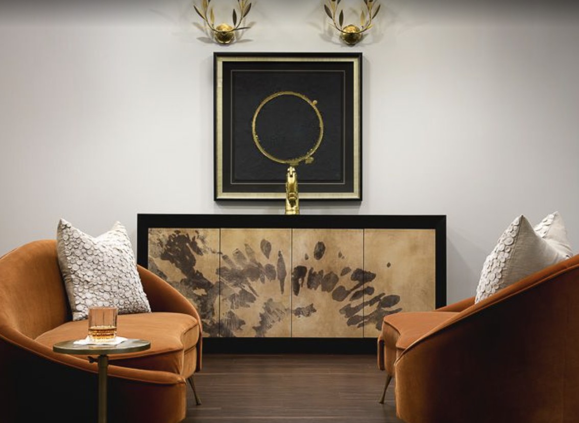 A contemporary lounge area featuring stylish armchairs, a unique sideboard with artistic patterns, and sophisticated wall art.