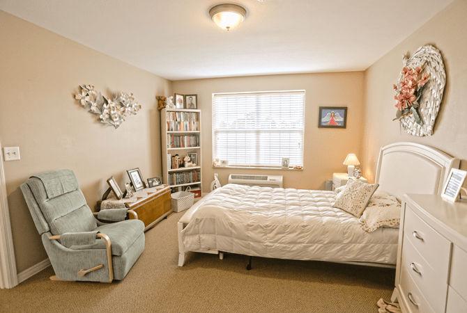 A cozy bedroom with a single bed and bookshelves, decorated in soft, neutral tones.