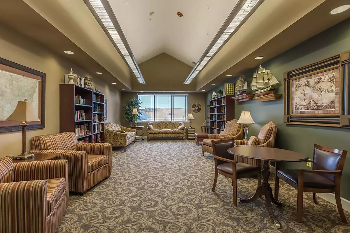 A cozy library sitting area with comfortable chairs and bookshelves.
