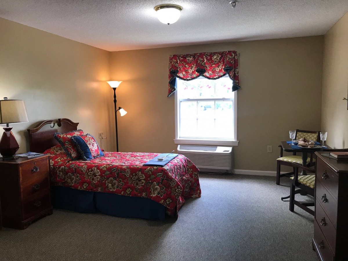 Cozy bedroom with a single bed, lamp, and window.