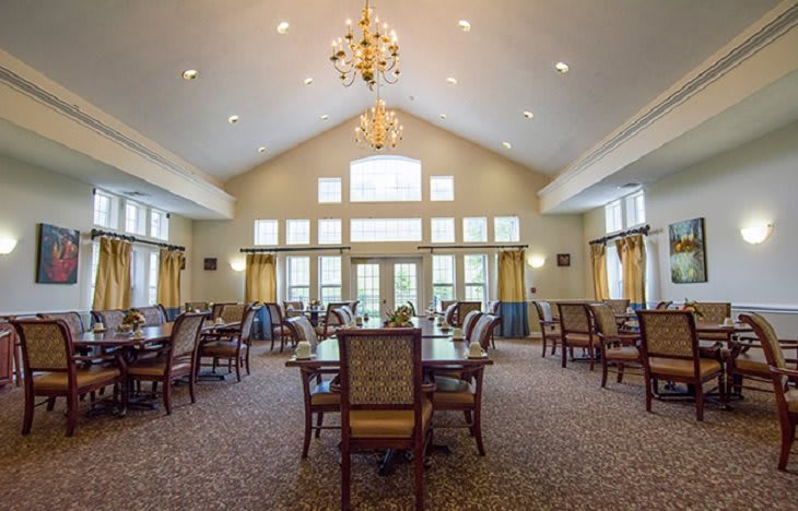 A spacious dining room with elegant furniture and a chandelier.