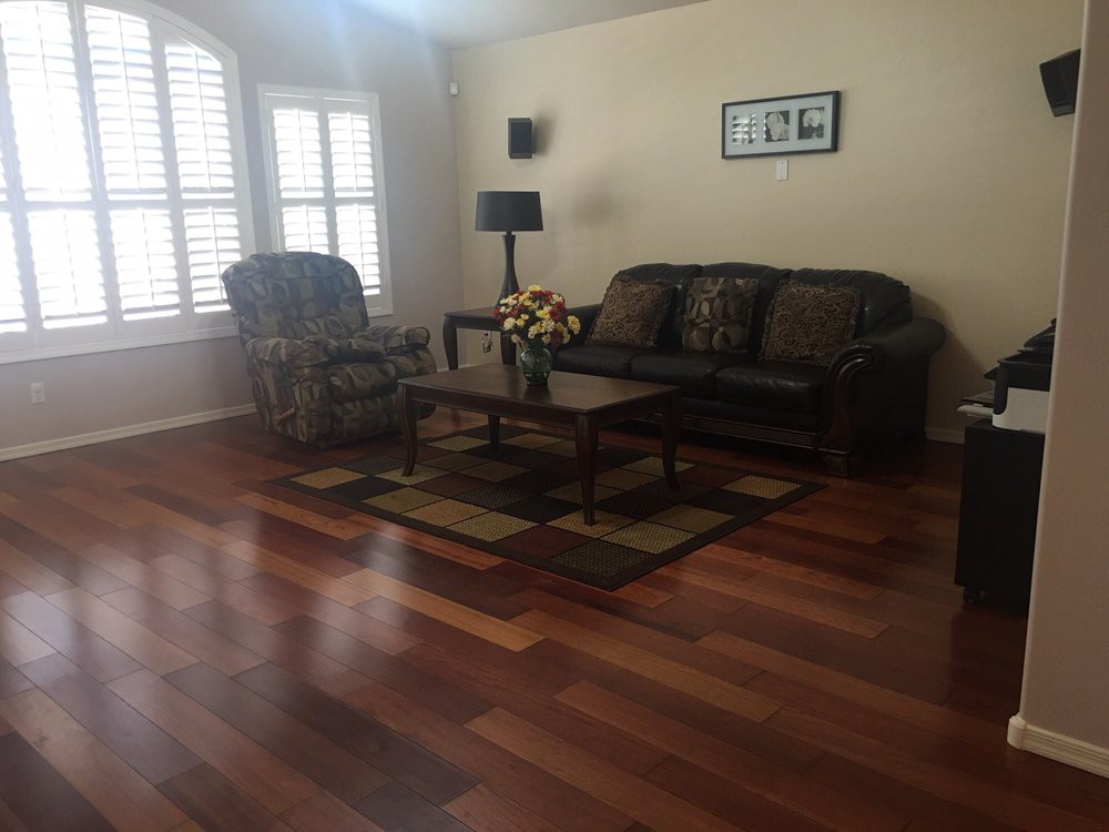A cozy living room with a sofa, armchair, and coffee table on a hardwood floor.