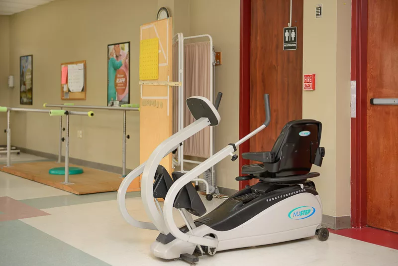 A recumbent exercise bike in a healthcare facility gym area.