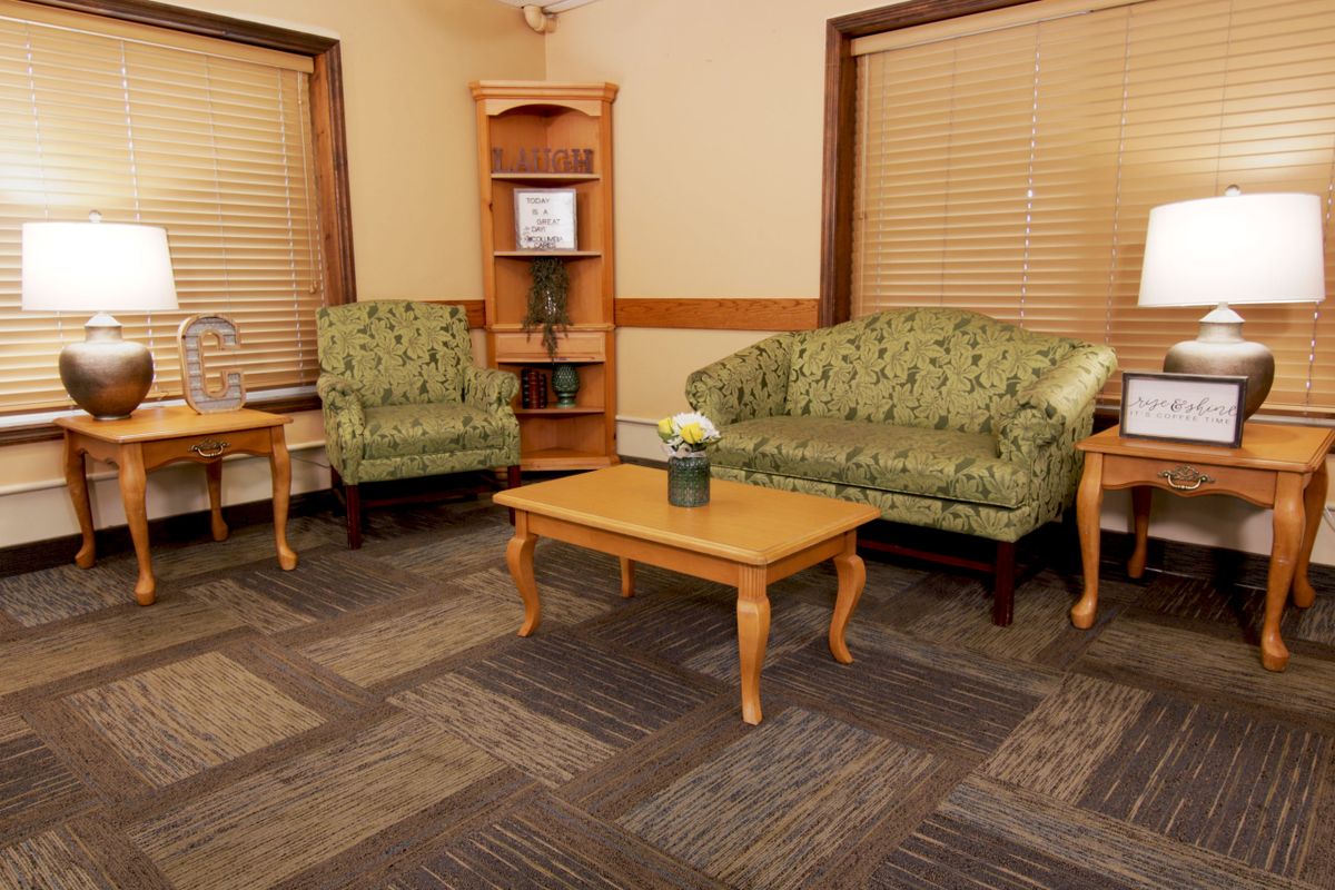 A cozy living room with green upholstered furniture and a wooden coffee table.