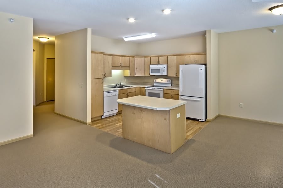 A modern kitchen with wooden cabinets, a central island, and various appliances.