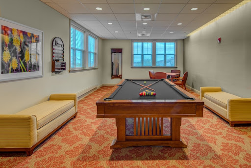 A cozy game room featuring a classic pool table and comfortable seating, perfect for leisure activities.