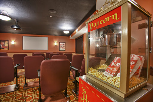 A cozy home theater setup featuring comfortable seating and a vintage popcorn machine.