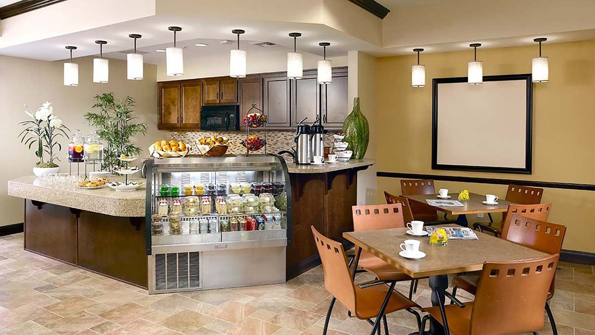 A cozy cafe interior with a seating area and a well-stocked counter display.
