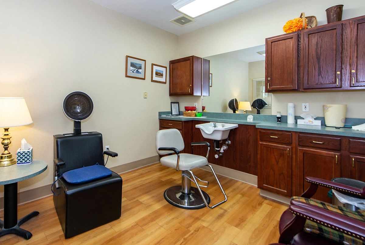 Interior of a cozy hair salon with styling chairs and a mirror.
