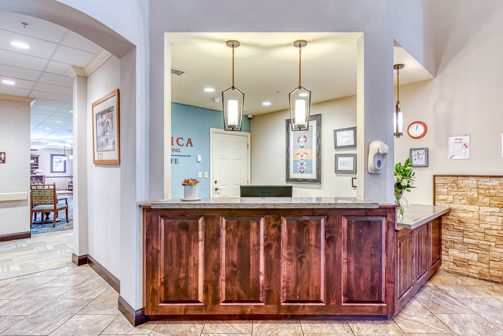 A welcoming office reception area with a wooden desk and modern lighting.