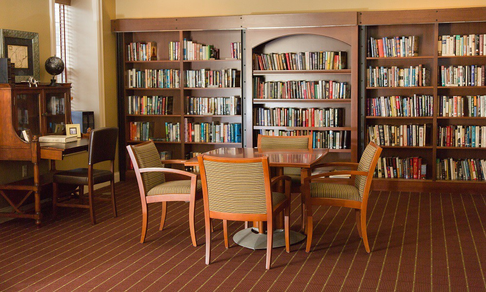 A cozy library corner with bookshelves, a table, and chairs.