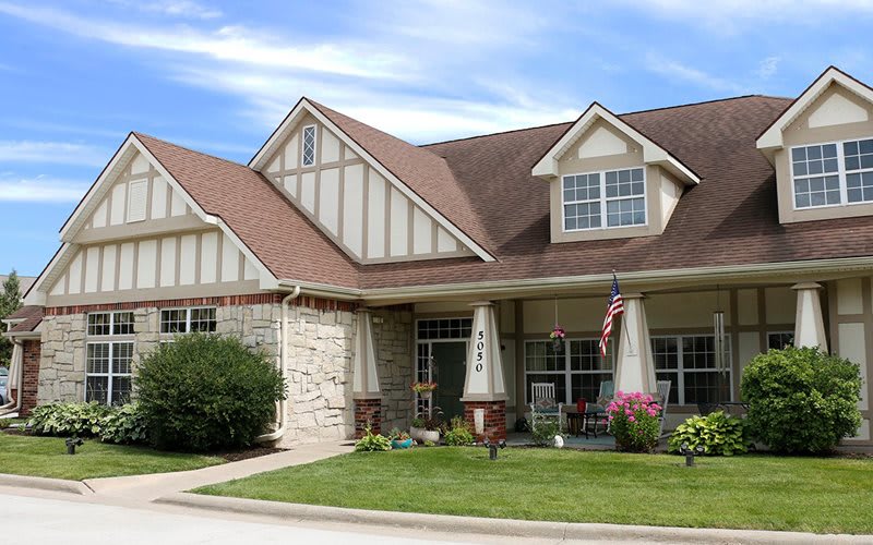 A charming suburban house with a well-maintained lawn and a cozy front porch.