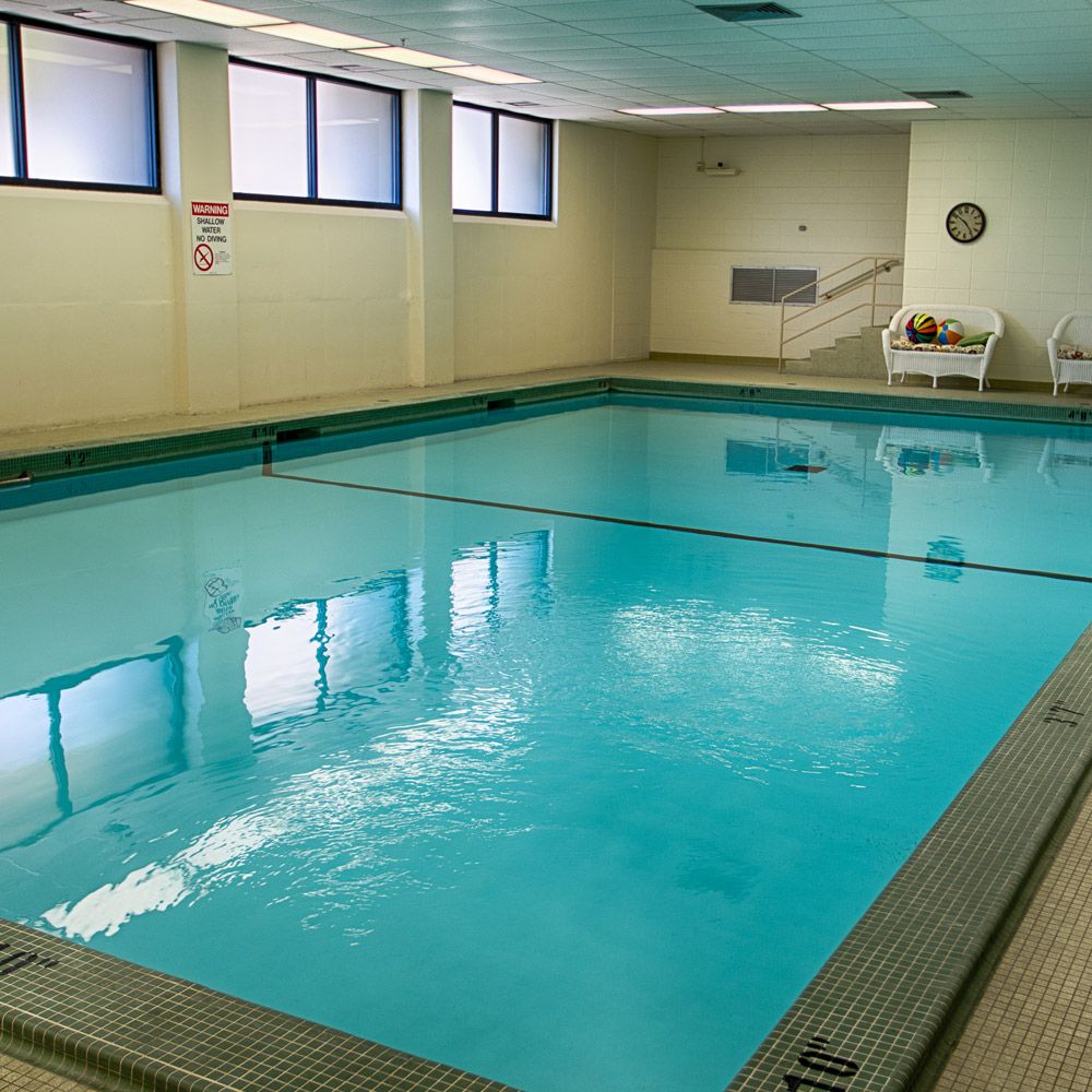 An indoor swimming pool with clear blue water and natural lighting.