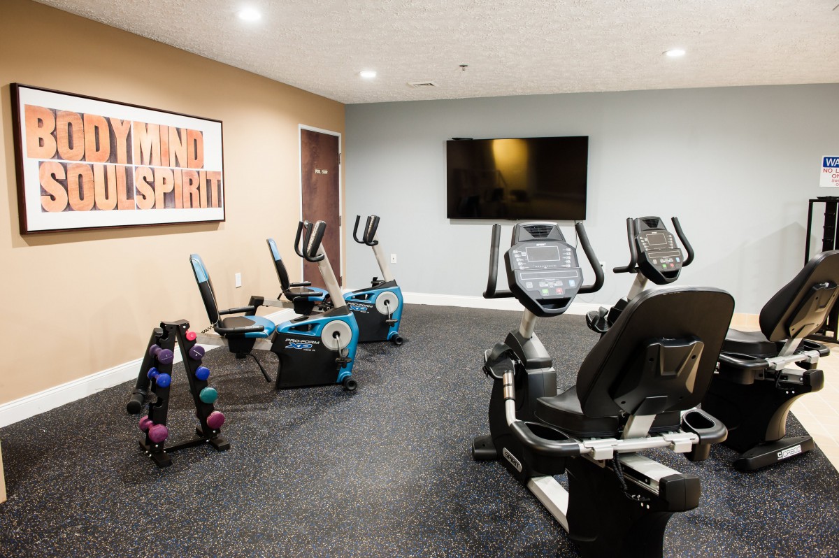 A modern indoor gym equipped with exercise bikes and a large television.