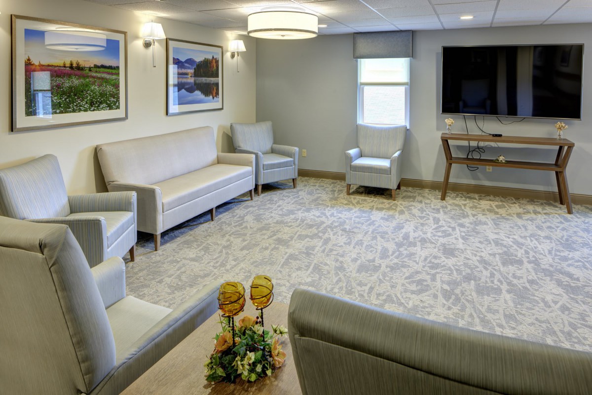 A well-furnished living room featuring sofas, chairs, a television, and tasteful decor.