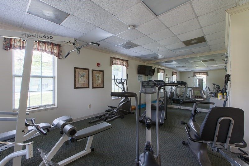 A well-equipped gym with various fitness machines and a large mirror.