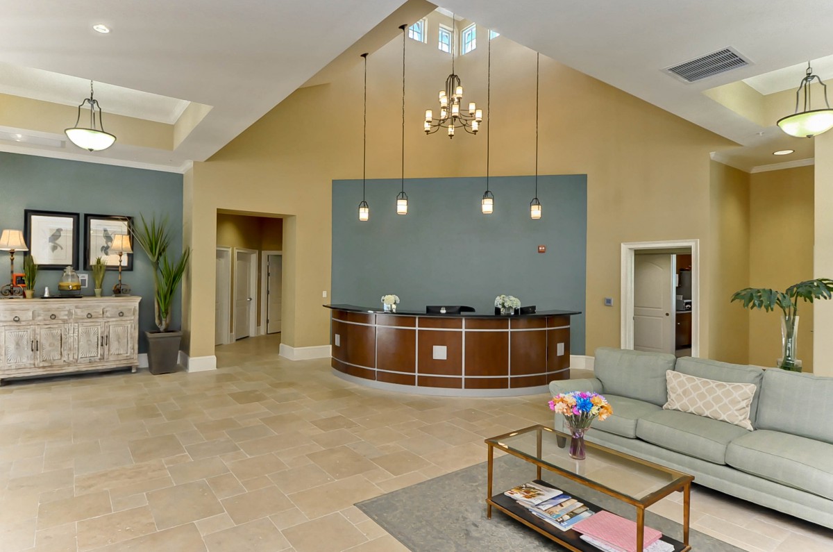 A modern lobby with a reception desk, comfortable seating, and elegant lighting.