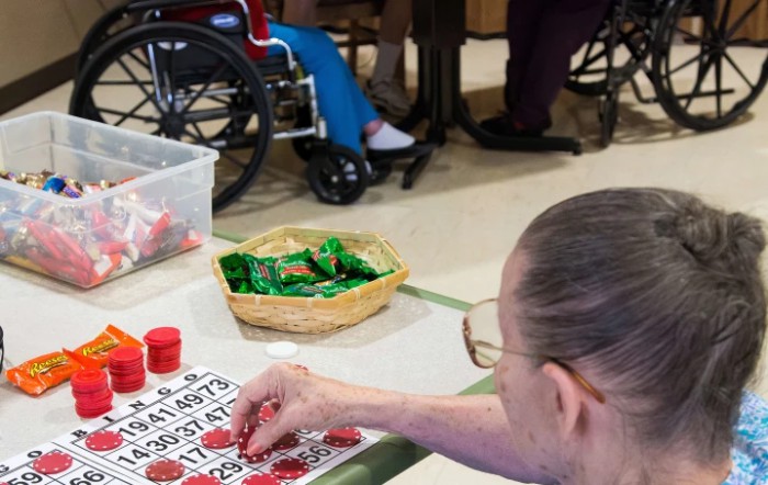 An elderly person playing bingo in a nursing home setting.