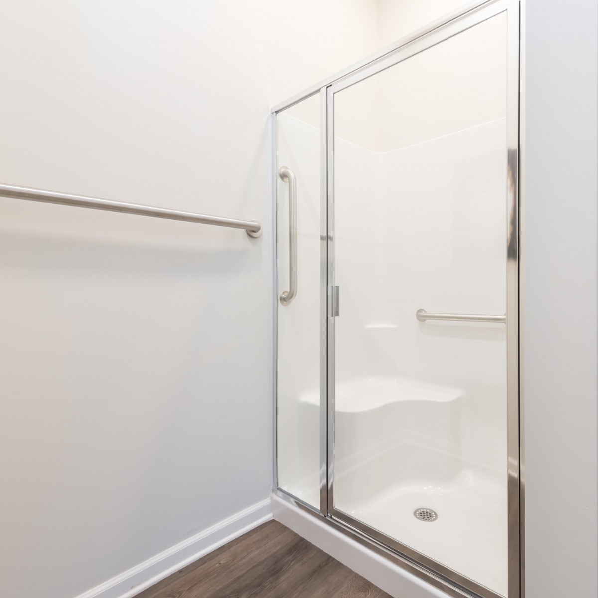A modern bathroom with a glass shower enclosure and minimalist design.