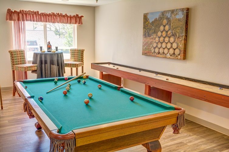 A cozy game room featuring a pool table and shuffleboard.
