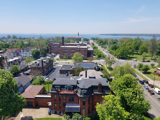 Aerial view of a scenic city landscape with lush greenery and a waterfront in the background.