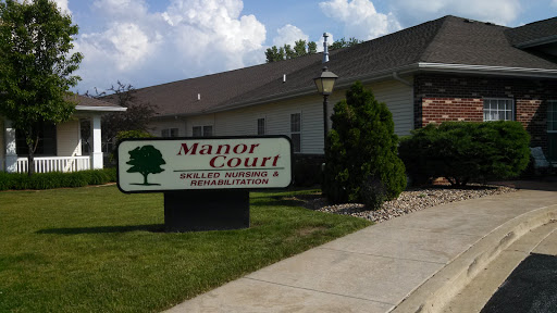 The exterior view of Manor Court, showcasing the building and its sign.