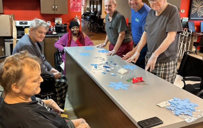 A group of people gathered around a table playing a game indoors.