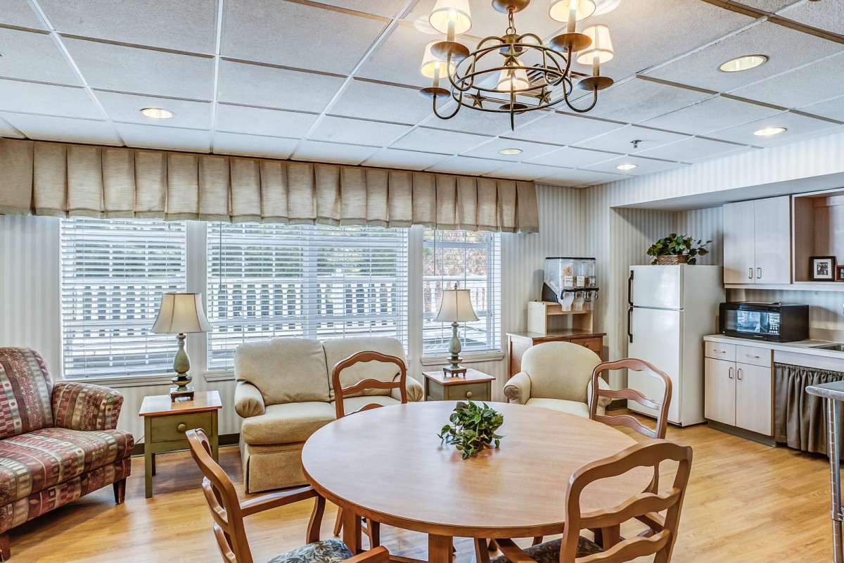 Cozy living and dining space with a round table, comfortable seating, and large windows.