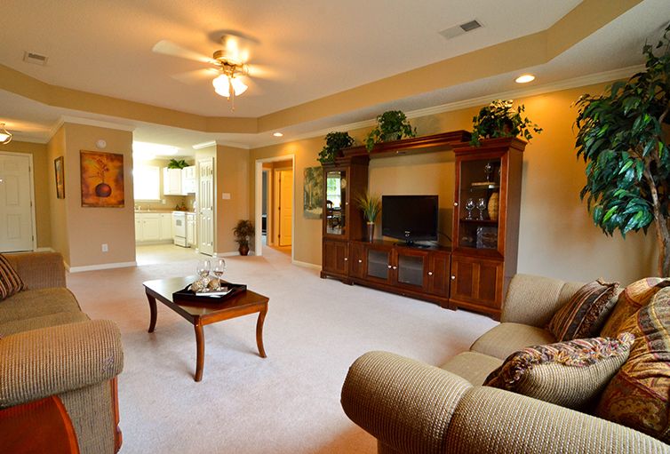 A cozy living room with a wooden entertainment center, comfortable seating, and elegant decor.