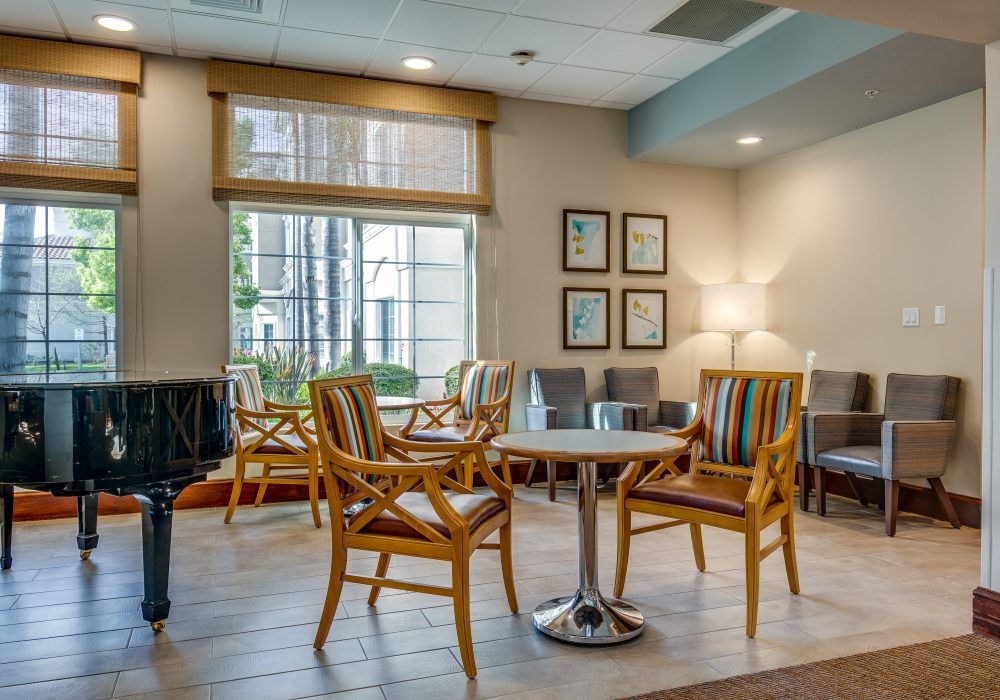 A cozy waiting room with chairs and a table near a large window.