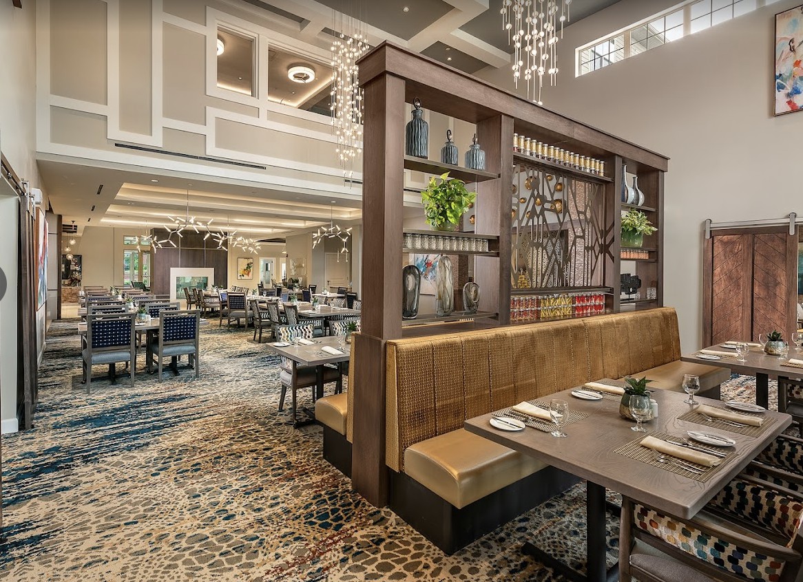 A modern restaurant interior featuring booth seating and elegant chandeliers.