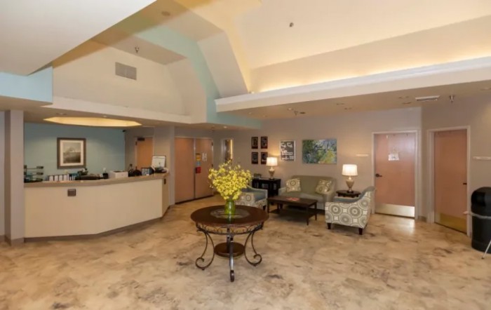 A cozy lobby with comfortable seating and a central table adorned with flowers.