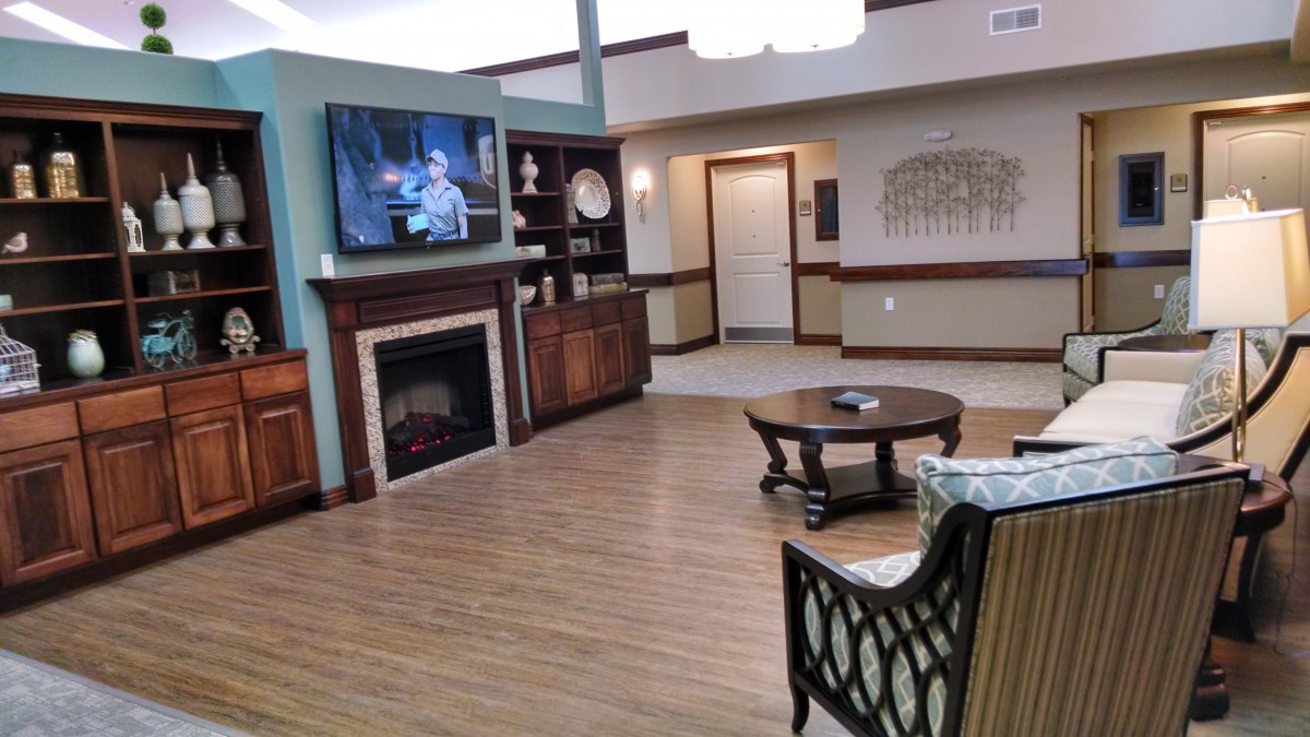 A cozy living room with a fireplace and television, featuring comfortable seating and a wooden coffee table.