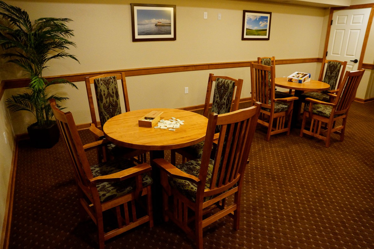A cozy room with wooden tables and chairs, decorated with wall art.