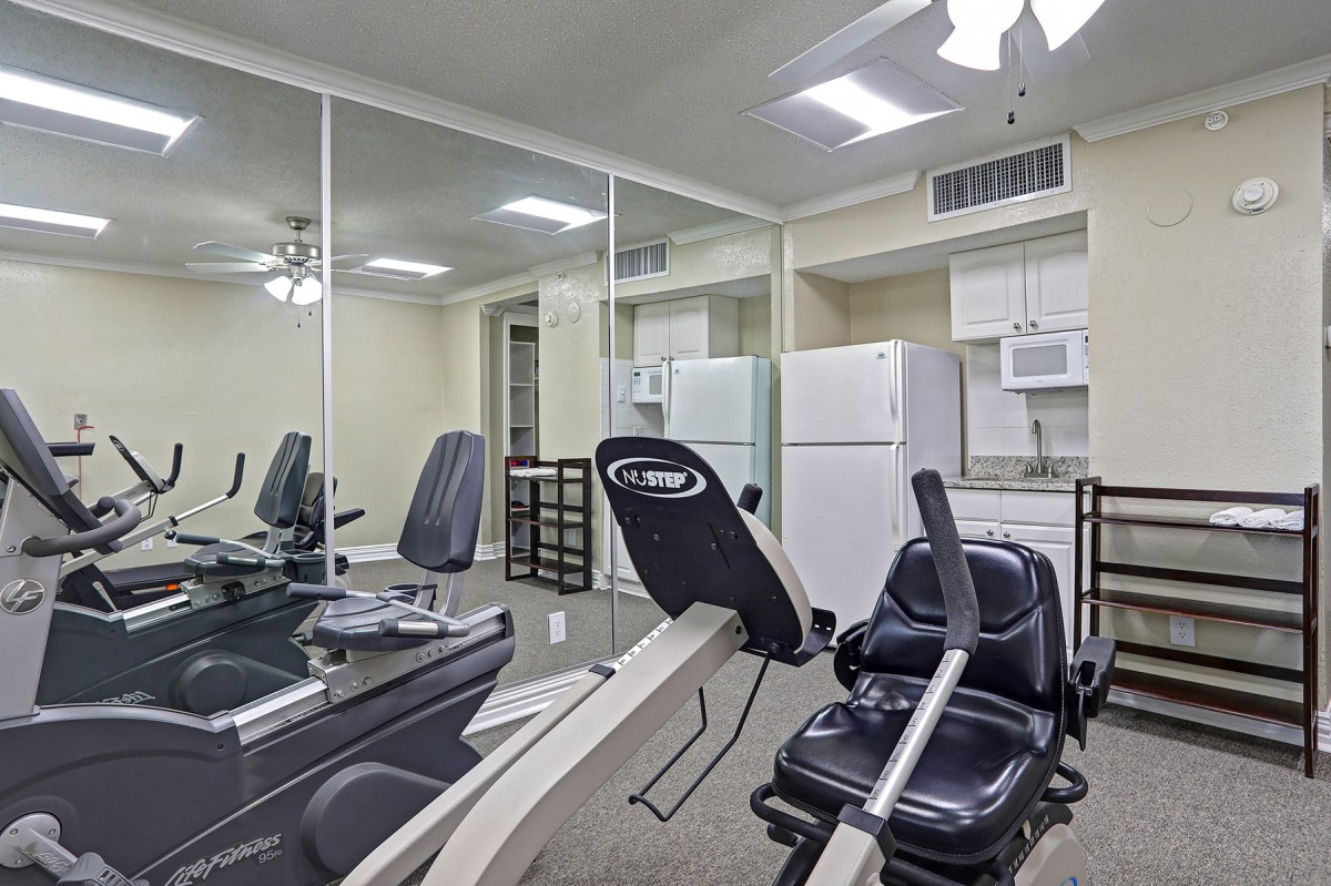 A home gym setup with exercise equipment adjacent to a kitchen area.