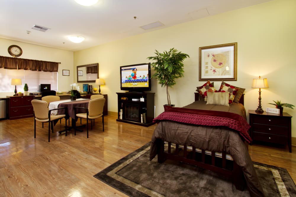 A cozy bedroom with an adjoining living area, featuring a bed, TV, and stylish decor.