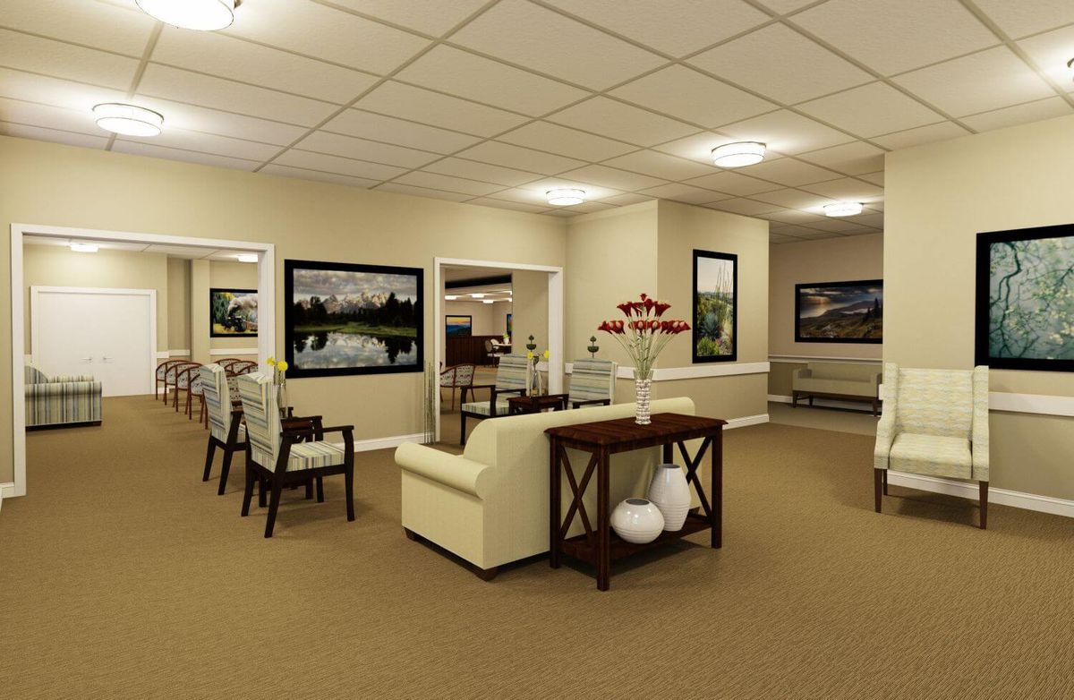 A cozy living room interior with a beige sofa, wall artwork, and warm lighting.