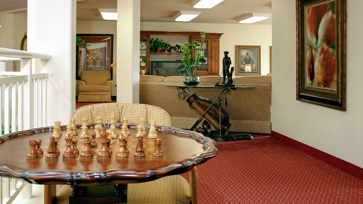 A cozy living room with a chess set on a table, surrounded by elegant furniture and decor.