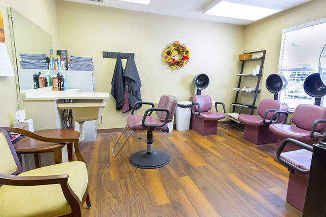 A cozy hair salon interior with stylish chairs and warm decor.