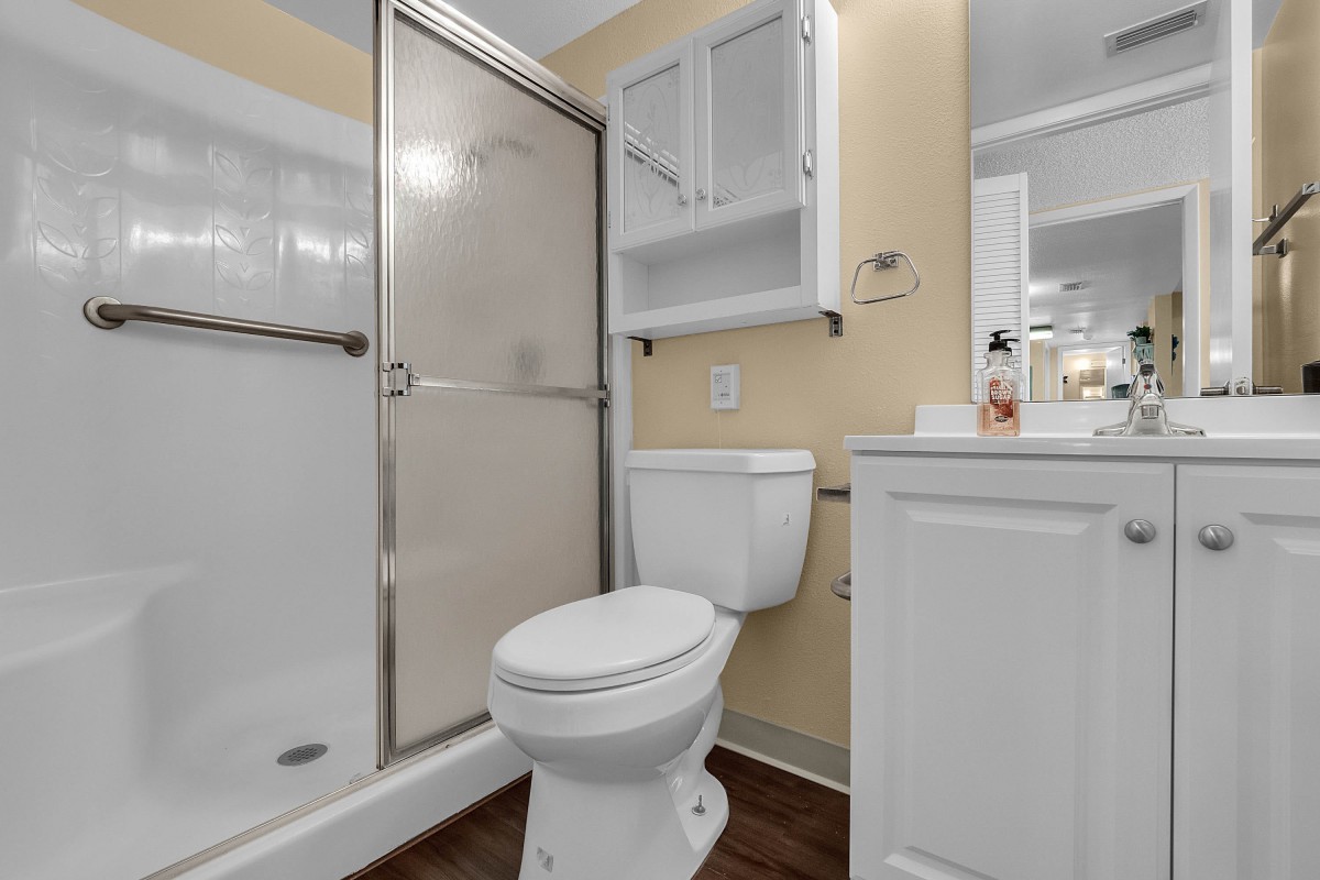 A modern bathroom with a shower, toilet, and sink.