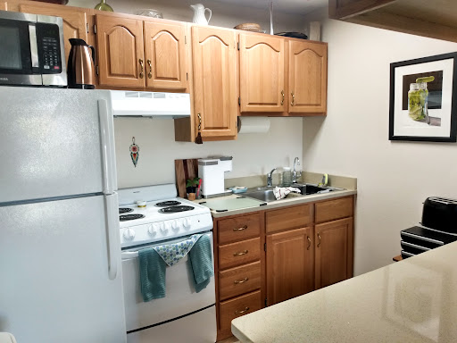 A cozy kitchen featuring wooden cabinets, a stove, and modern appliances.