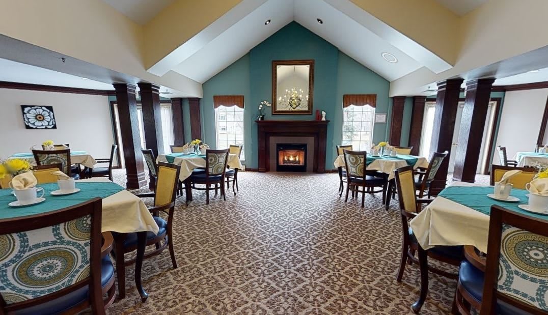 A cozy dining room with a fireplace, tables, and chairs in an elegant setting.