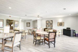 A bright and modern dining room featuring several tables and chairs with neutral decor.