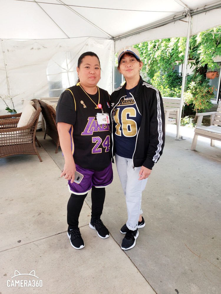 Two friends posing outdoors in sports jerseys.