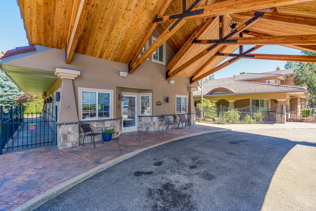 The entrance of a building with a covered walkway and wooden beams.