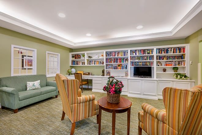 A cozy living room with bookshelves, a seating area, and a television.