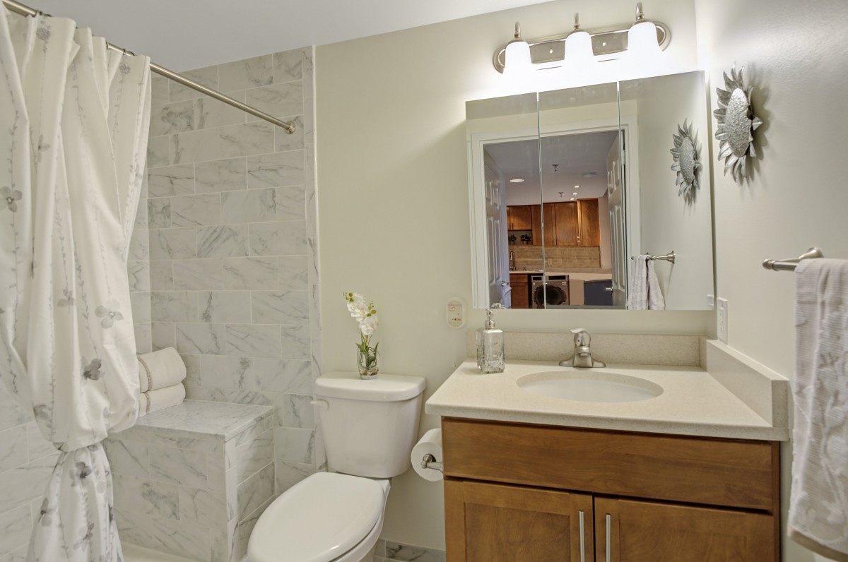 A modern bathroom with a sink, toilet, and shower area.