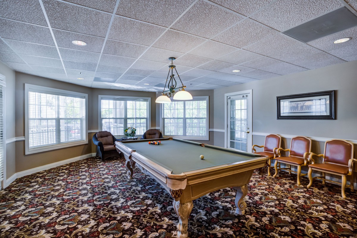 A cozy game room featuring a pool table and comfortable seating.