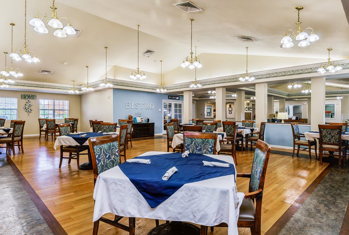 A well-lit dining room with tables and chairs neatly arranged.