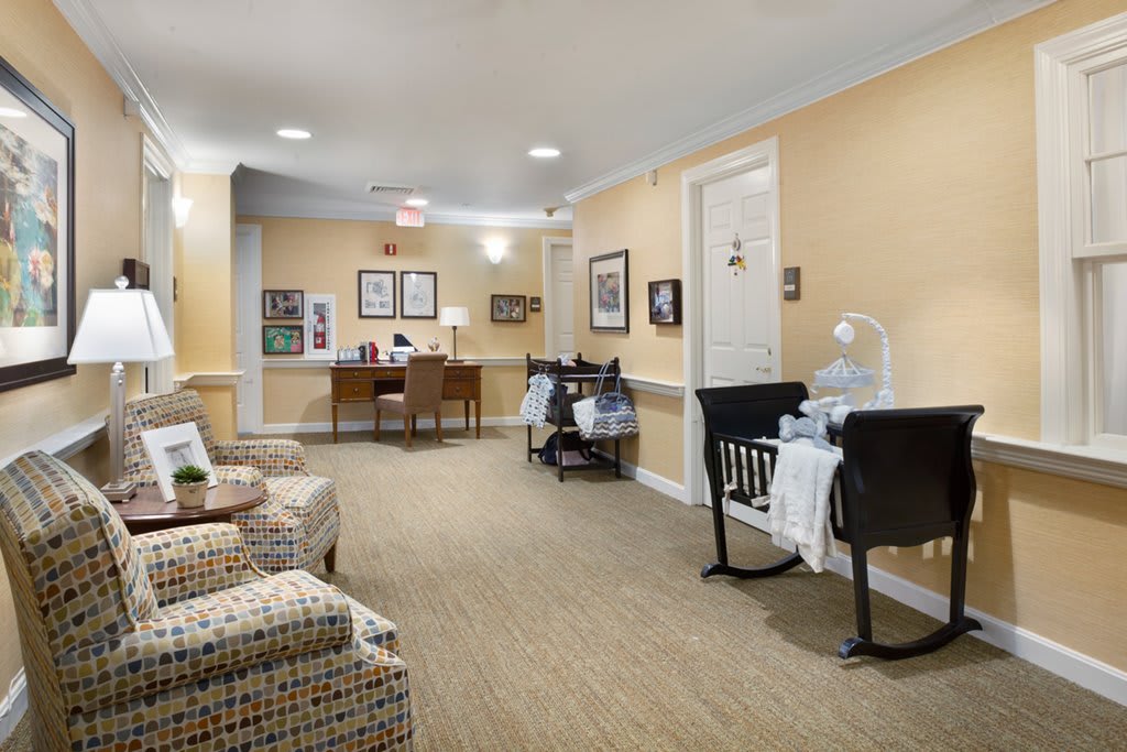 A cozy lobby area featuring comfortable seating and a small desk in a warmly lit hallway.
